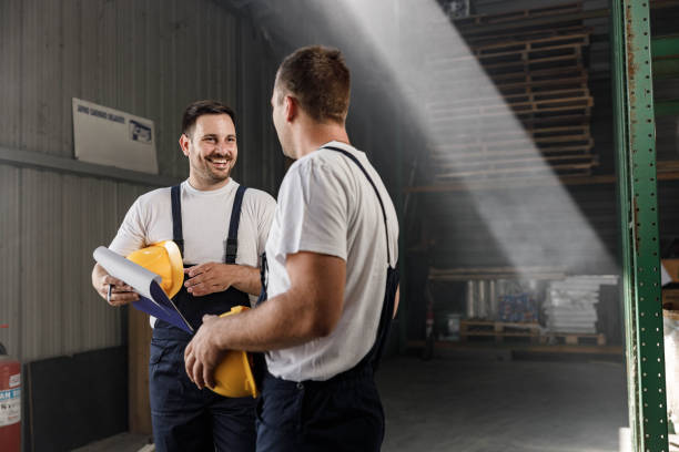 istock Happy manual workers talking to each other in a warehouse. 2173051523