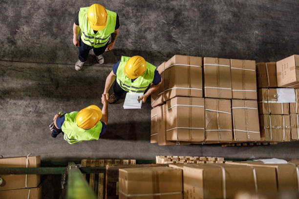 istock Above view of manual workers shaking hands in a warehouse. 2173051588