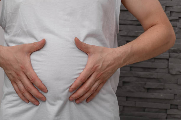 istock Overweight man holding his swollen, round belly 2173059249