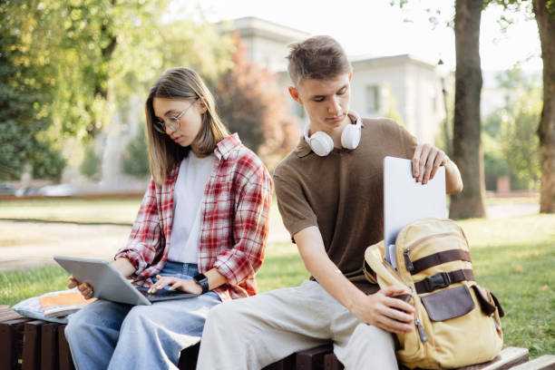 istock Couple of Students Preparing for Study on a Park Bench 2173062673