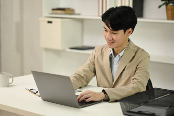istock Handsome young businessman in formal suit working with laptop at office 2173068713
