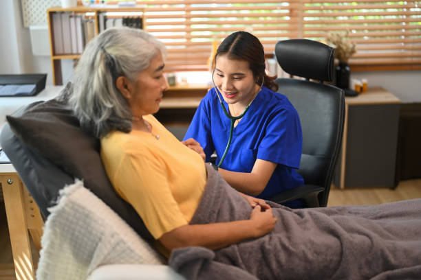 istock Smiling female general practitioner examining with stethoscope senior patient in clinic 2173068828