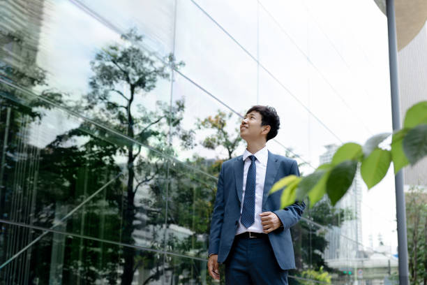 istock Businessman standing office building with trees. 2173069914