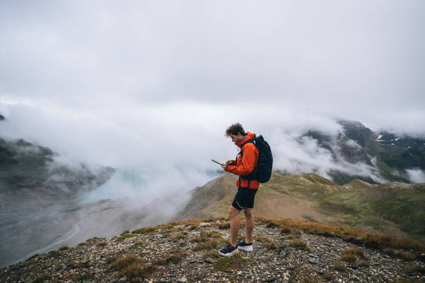 istock Backpacker uses digital tablet above alpine lake 2173072486