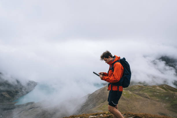 istock Backpacker uses digital tablet above alpine lake 2173072596