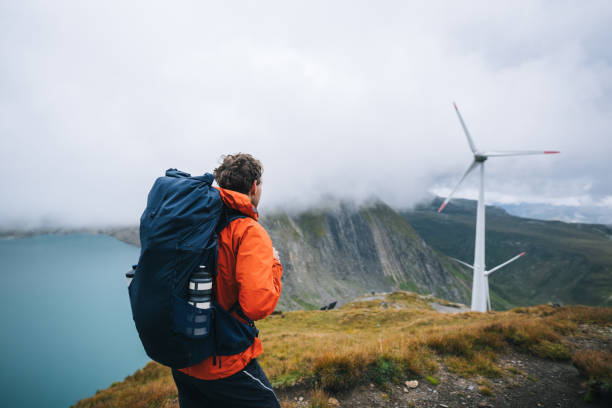istock Backpacker hikes above wind turbines and lake 2173073470