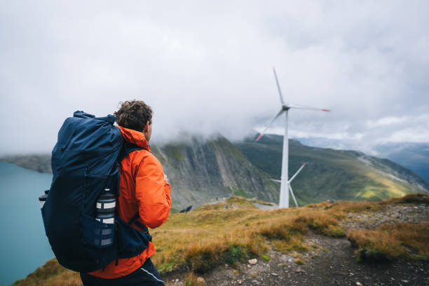 istock Backpacker hikes above wind turbines and lake 2173073488