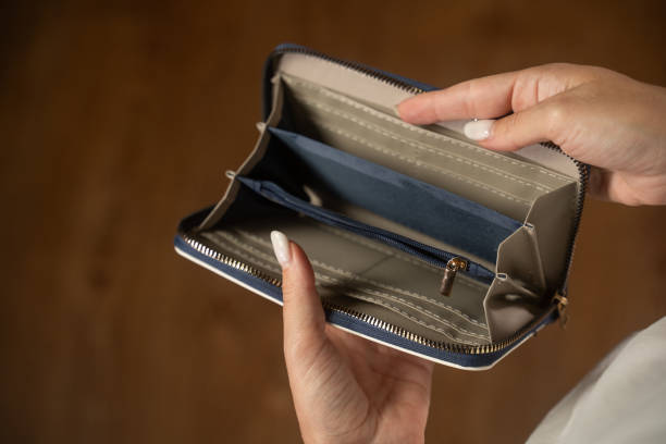 istock Woman displaying an empty wallet to highlight financial hardships 2173073931