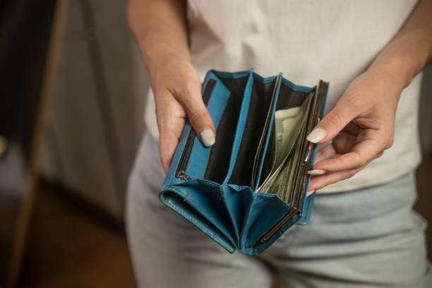 istock Woman taking out us dollar banknotes from blue wallet 2173074464