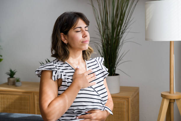 istock Young woman practicing deep breathing exercise at home 2173076229