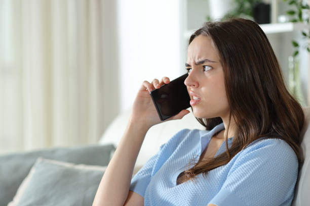 istock Disgusted woman talking on phone at home 2173081954
