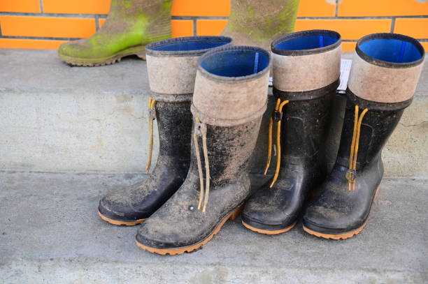 istock Outdoor Work Boots with Mud Stains on Cement Ground 2173084682