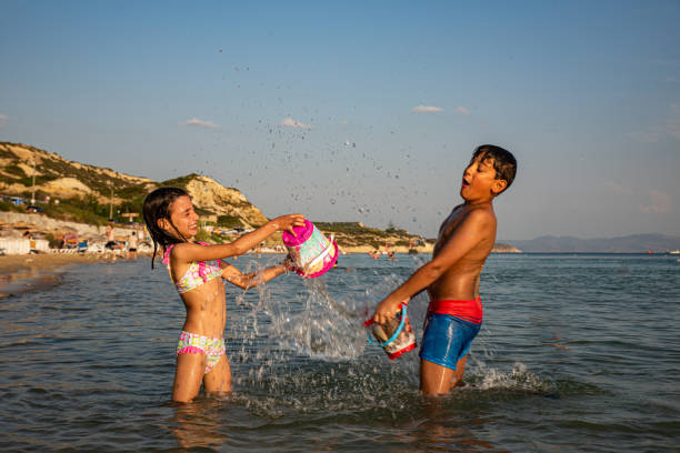 istock Kids playing water pranks on the beach 2173085533