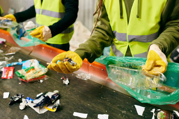 Young volunteers sort waste at a community cleanup for a sustainable lifestyle A group of passionate youth sorts through trash, demonstrating eco-friendly actions and teamwork in action. sorter machine stock pictures, royalty-free photos & images