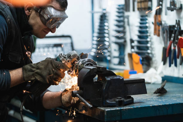 istock Attentive repairman cutting metal with electric grinder in workshop 2173088607