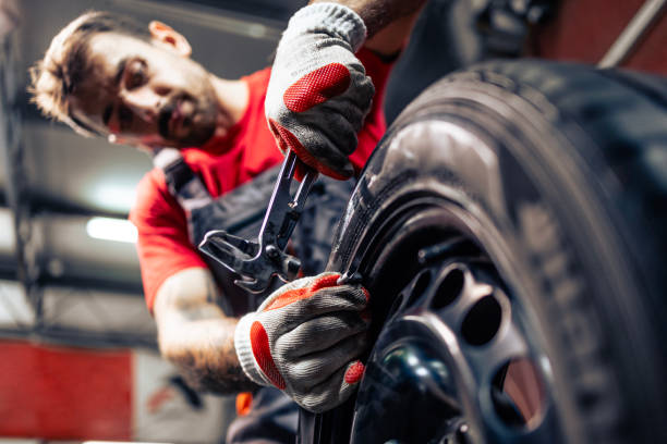 istock Tire repairman adding weight and balancing car wheel. 2173089789