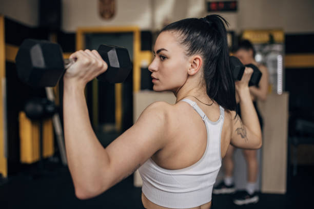 istock Side view of determined woman lifting dumbbells 2173091464