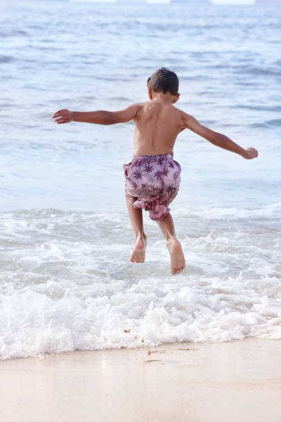 istock Boy jumping in sea waves 2173092947