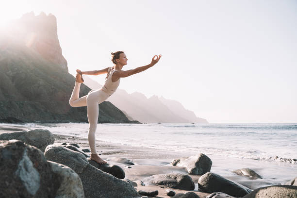 istock Woman is practicing yoga on the beach. 2173093721