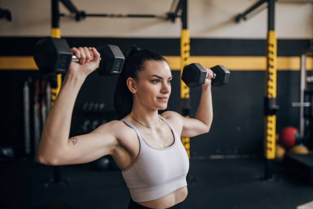 istock Woman lifting dumbbells during gym workout session 2173094036