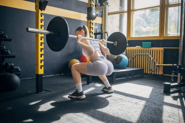 istock Woman performing squat under weights in the gym. 2173094900