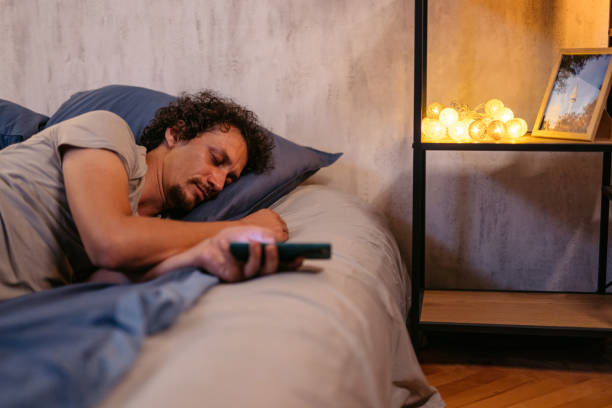 istock Mid-Adult Man Falling Asleep While Using His Phone In The Bed At Night 2173097165