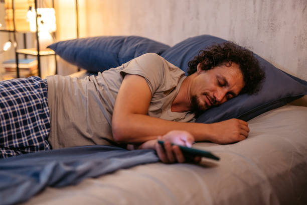istock Mid-Adult Man Falling Asleep While Using His Phone In The Bed At Night 2173097541
