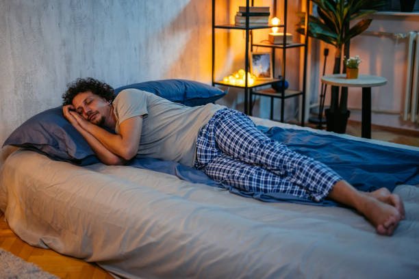 Handsome mid-adult man sleeping in the bed at night in his bedroom.