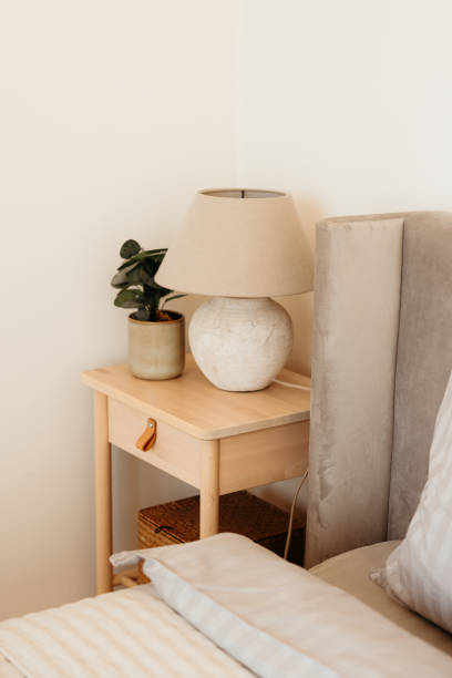 istock Bedside table with a lamp and a plant is standing near a comfortable bed 2173110310