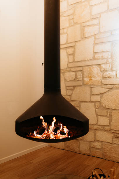 istock Modern hanging fireplace burning inside a cozy cabin 2173110531