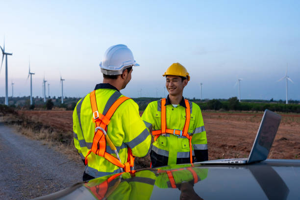 istock Diverse ethnicity male technicians working in the wind turbines field. Innovation engineer men use laptop computer work to develop environmental renewable clean energy outdoors at windmill power farm. 2173110538