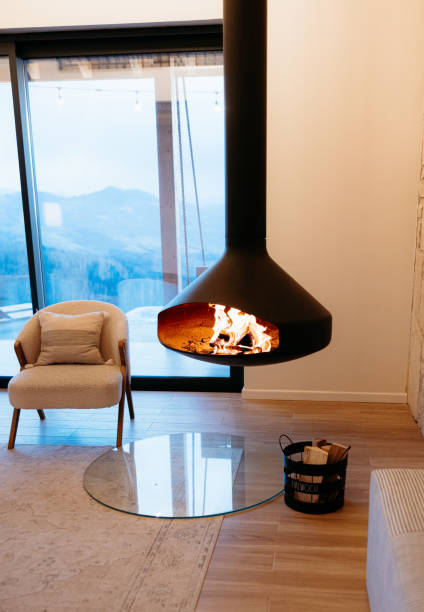 istock Modern hanging fireplace burning inside a cozy cabin with mountain view 2173110921