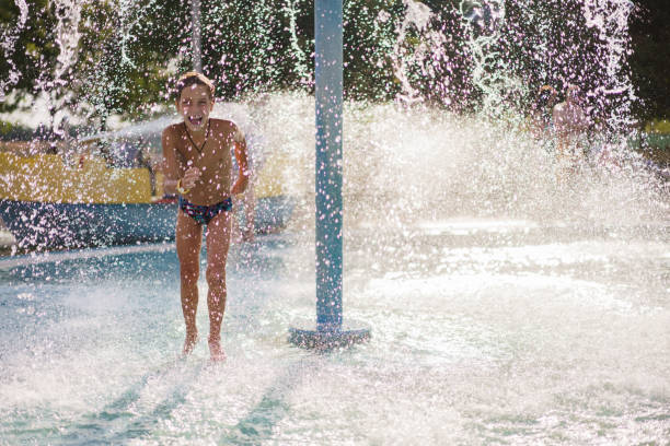 istock Boy having fun under waterfall in water park 2173111869
