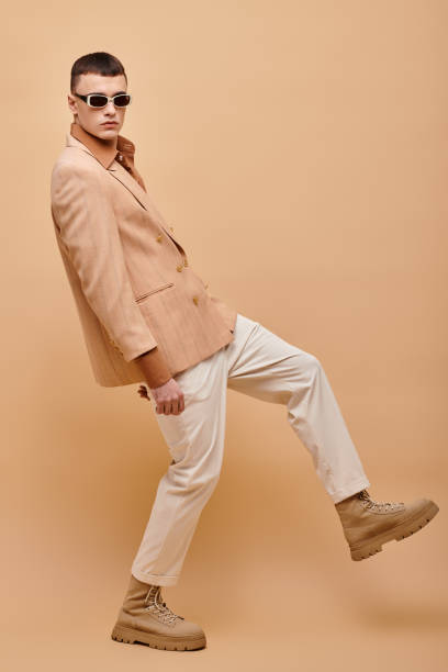 istock A dapper man showcases his style with confidence against a warm, vibrant backdrop 2173112757