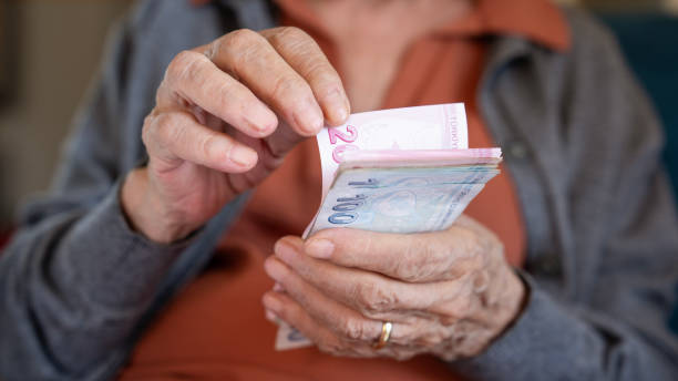 istock Old woman counting Turkish lira banknotes 2173112958