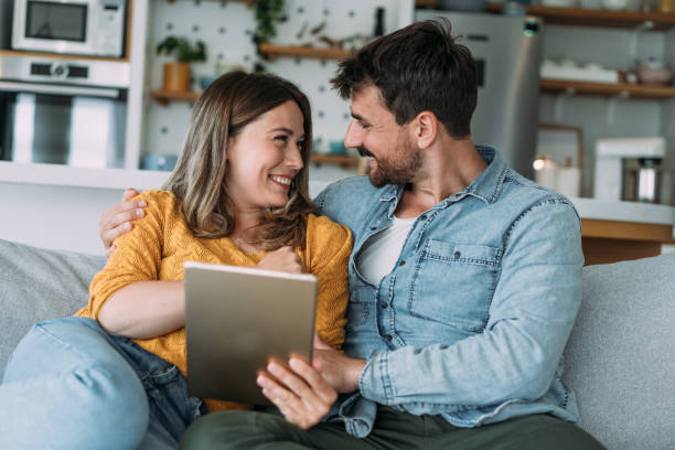 istock Smiling young couple using digital tablet at home. 2173113656