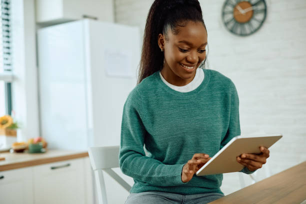 istock Happy black woman using digital tablet at home. 2173118945