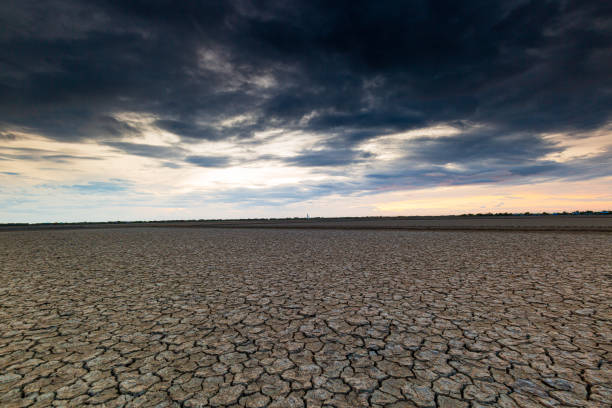 istock Arid landscape,Dry barren land with cloudy polluted sky, climate change and desertification concept 2173121304