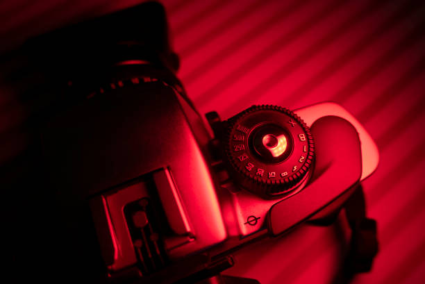 Vintage camera with lens in red light environment. Photography concept and copy space