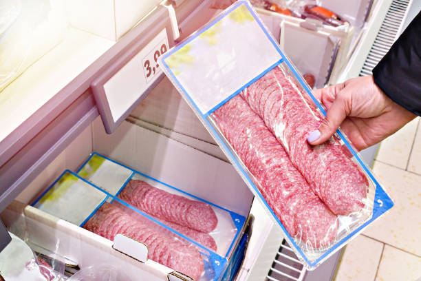 istock Sliced sausage in hands in store 2173125055