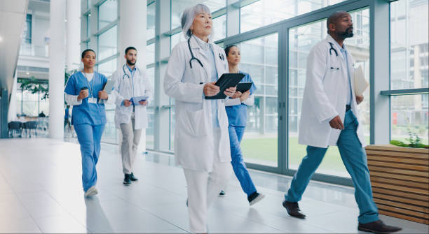 istock Doctors, group and walking in corridor at hospital with tablet, documents and diversity for healthcare. People, team and medical staff with solidarity, wellness and services with synergy at clinic 2173126962