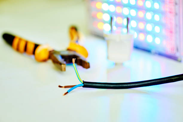 Electrical equipment for connection.Three-core electric cable, metalwork pliers and LED lamp