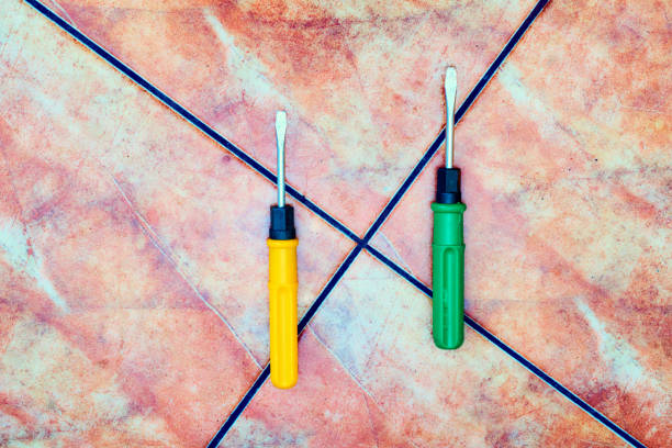 a tool with a flattened, cross-shaped, or star-shaped tip that fits into the head of a screw to turn it