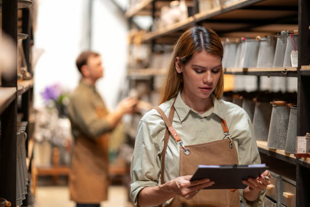 istock A manager of a home decor store is seen checking inventory using a digital tablet and checklist in the warehouse, reflecting careful stock management practices. Wearing an apron, the manager focuses on ensuring the business operates efficiently. 2173134100