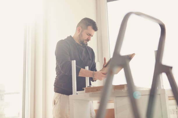 istock Man working and assembling furniture in a new apartment. 2173138943