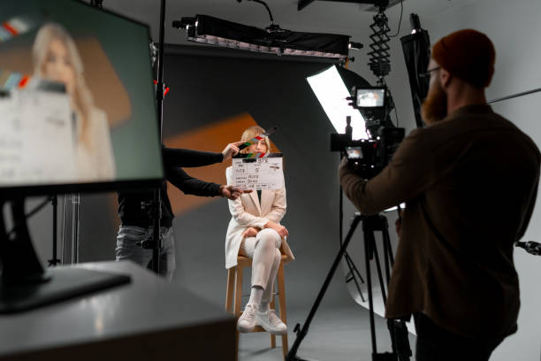 istock Woman gestures with clapper board in front of man, creating fun event display 2173151229