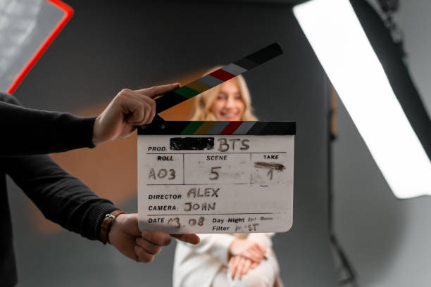 istock Woman gestures with clapper board in front of man, creating fun event display 2173151303