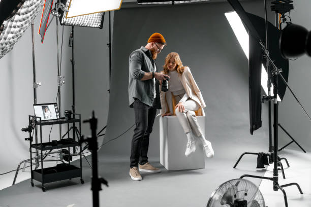 istock Professional Fashion Photoshoot: Photographer Adjusting Model's Pose in Studio Light Setup 2173155170