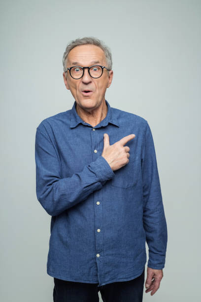 istock Portrait of surprised senior man pointing at copy space 2173156014