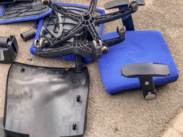 High angle close-up view of a broken to pieces office chair in the street